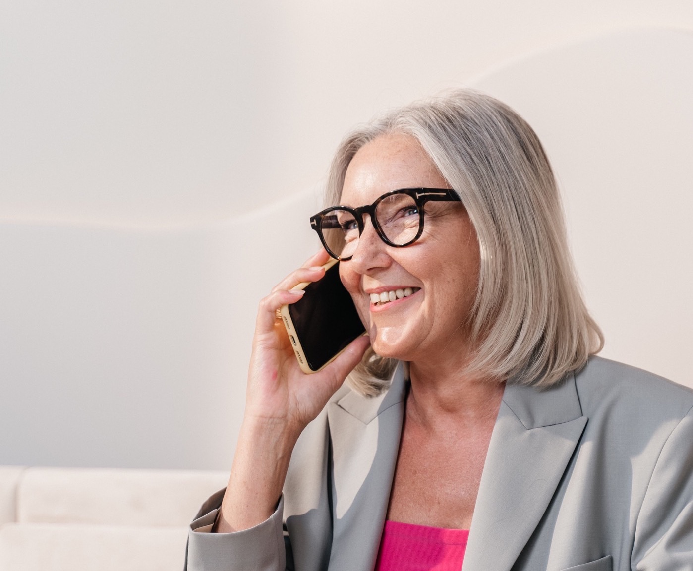 A smiling customer calls a restaurant on her phone